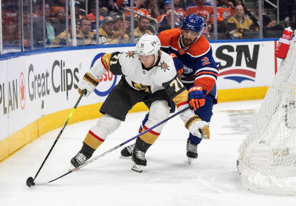 Vegas Golden Knights' William Karlsson (71) and Edmonton Oilers' Evan Bouchard (2) battle for t ...