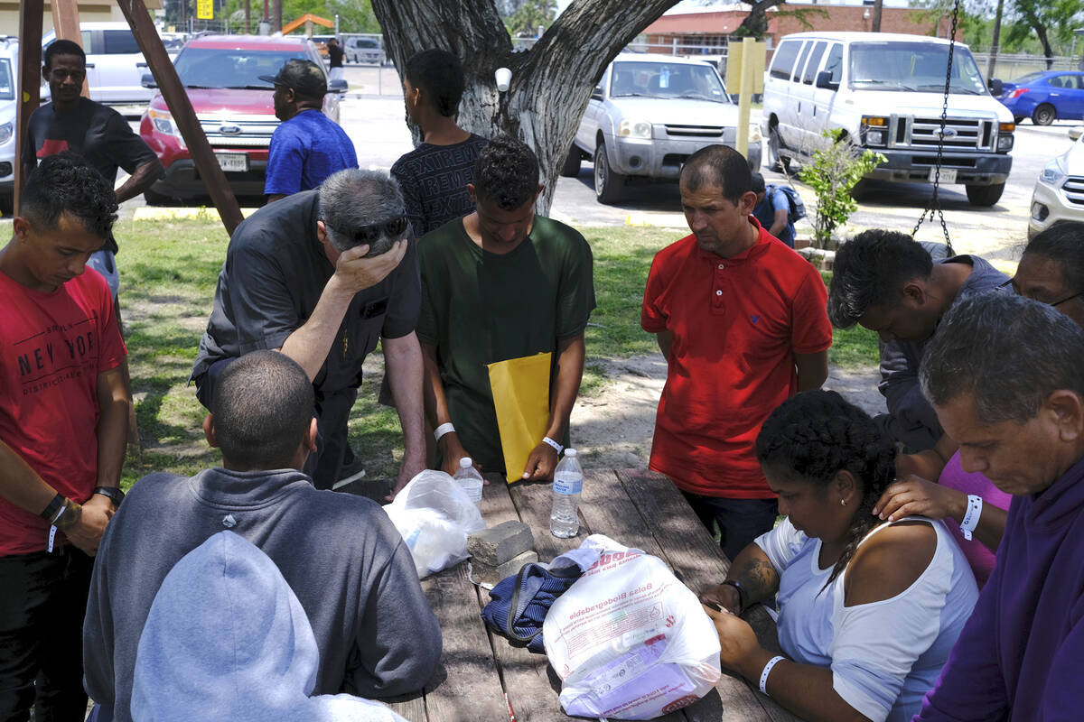 Father Kevin Collins, OMI, pastor at St. Eugene de Mazenod Parish, places his hand on his foreh ...