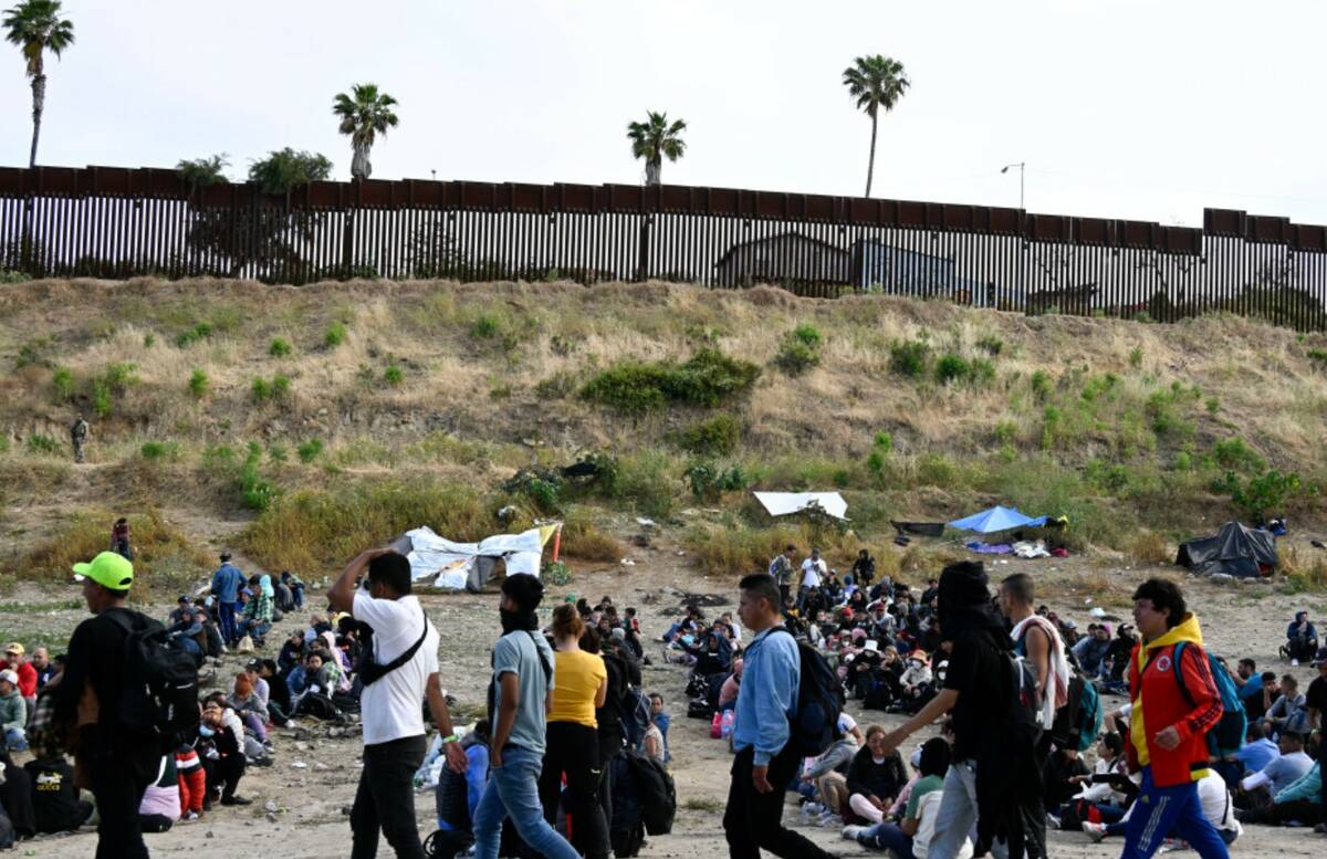 Asylum seekers wait between the double fence on U.S. soil along the U.S.-Mexico border near Tij ...