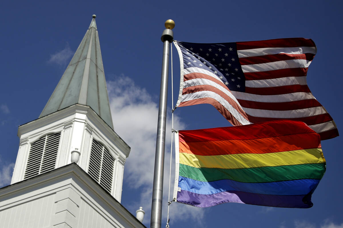 FILE - In this April 19, 2019 file photo, a gay pride rainbow flag flies along with the U.S. fl ...