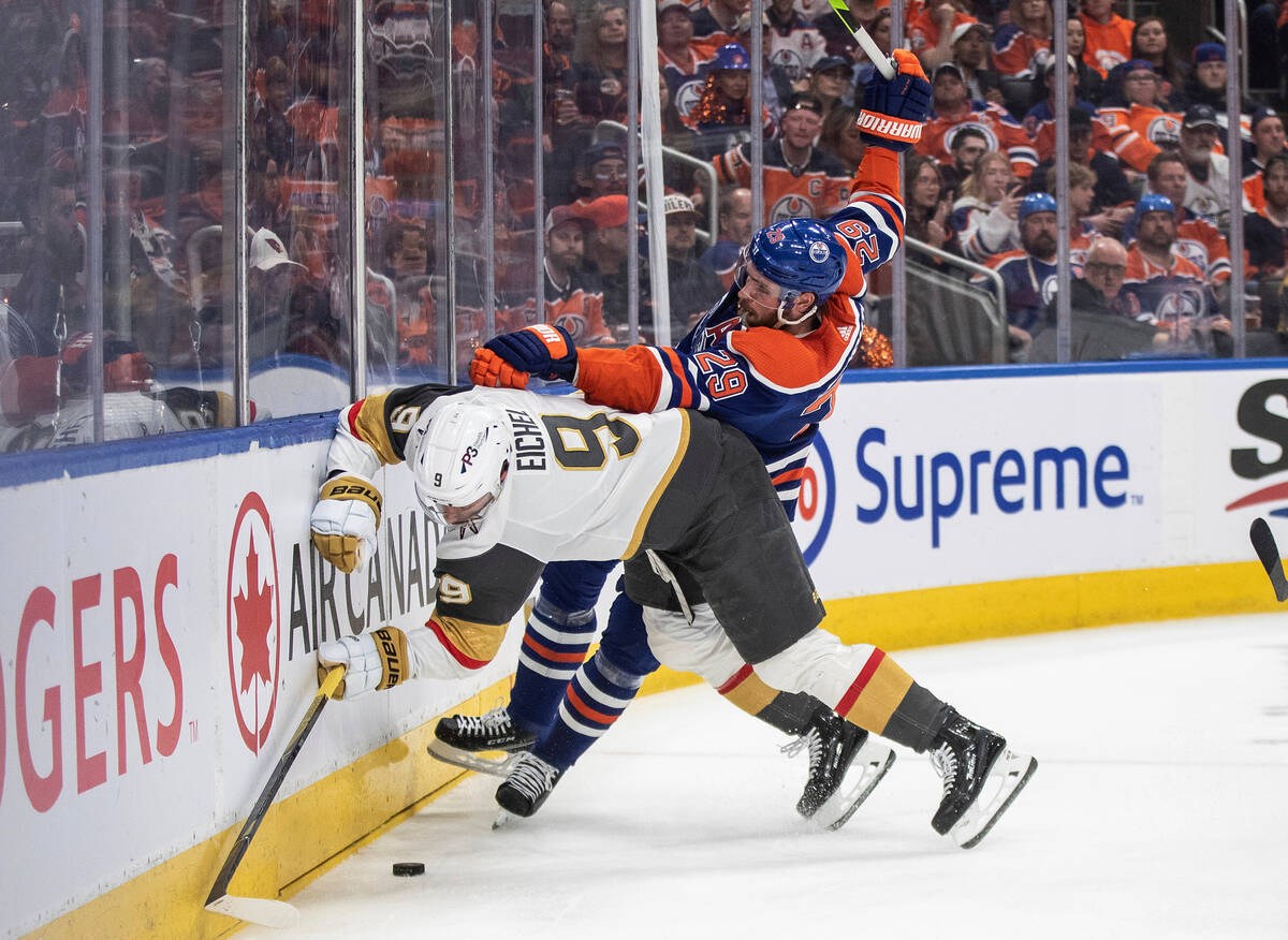 Vegas Golden Knights' Jack Eichel (9) is checked by Edmonton Oilers' Leon Draisaitl (29) during ...