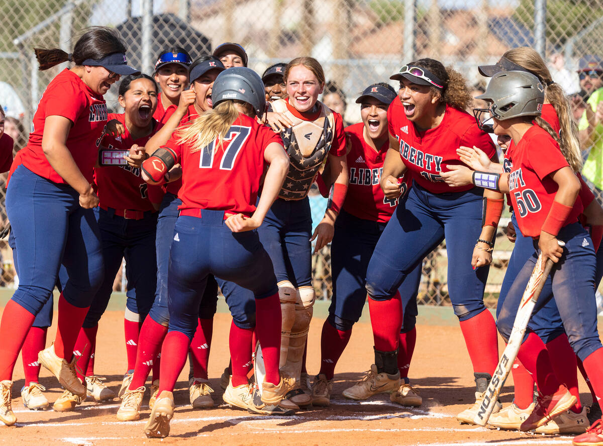 Liberty High's Jesse Farrell (17) is greeted by her teammates after hitting a solo homer agains ...