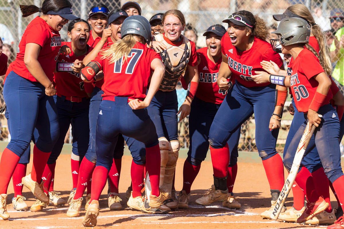 Liberty High's Jesse Farrell (17) is greeted by her teammates after hitting a solo homer agains ...