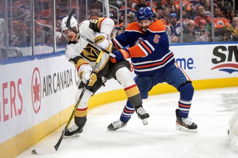Vegas Golden Knights' Jack Eichel (9) and Edmonton Oilers' Cody Ceci (5) battle for the puck du ...