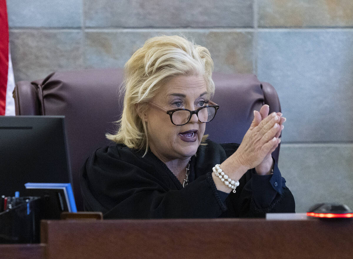 District Judge Michelle Leavitt speaks to former Clark County Administrator Robert Telles, who ...