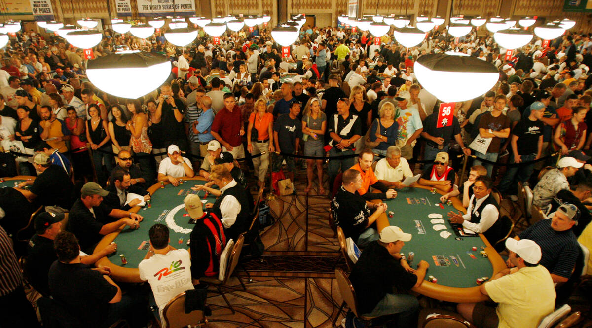 Spectators gather around tables as players take part in the first day of the World Series of Po ...