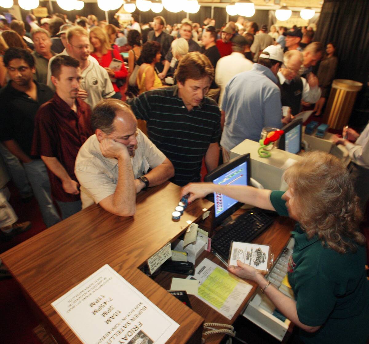 James McClendon from Henderson watches while Bonnie Smith from Binion's Horseshoe counts out $1 ...