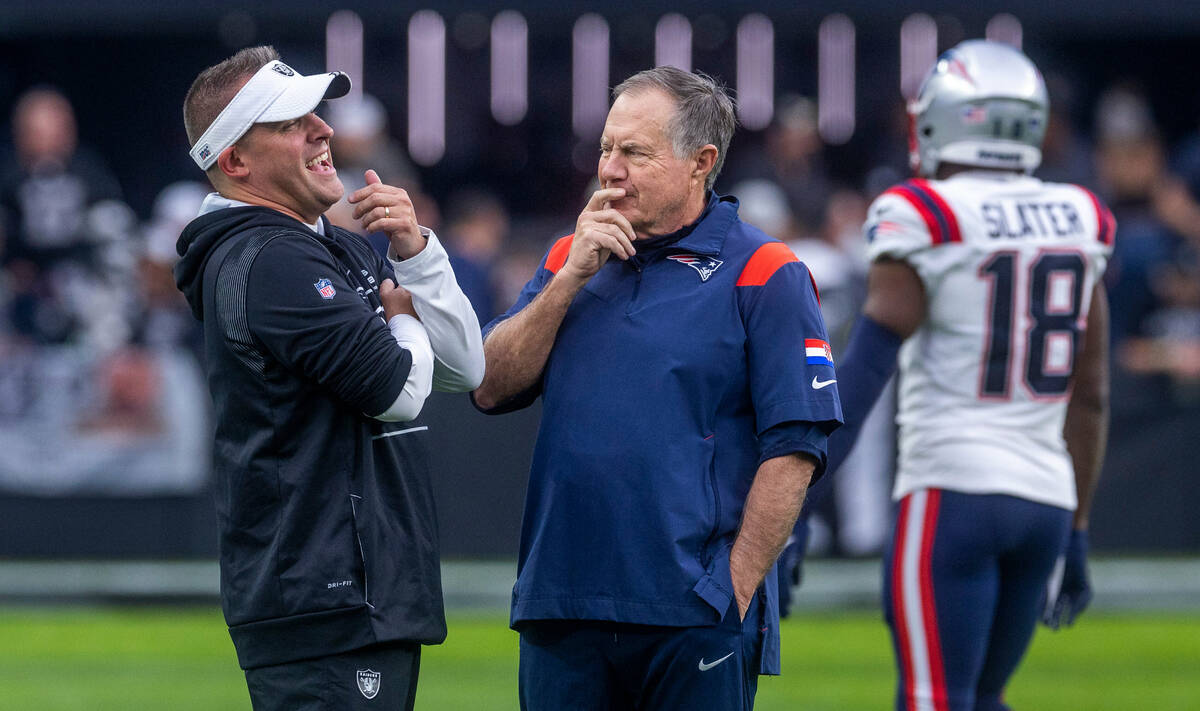 Raiders Head Coach Josh McDaniels talks with New England Patriots Head Coach Bill Belichick dur ...