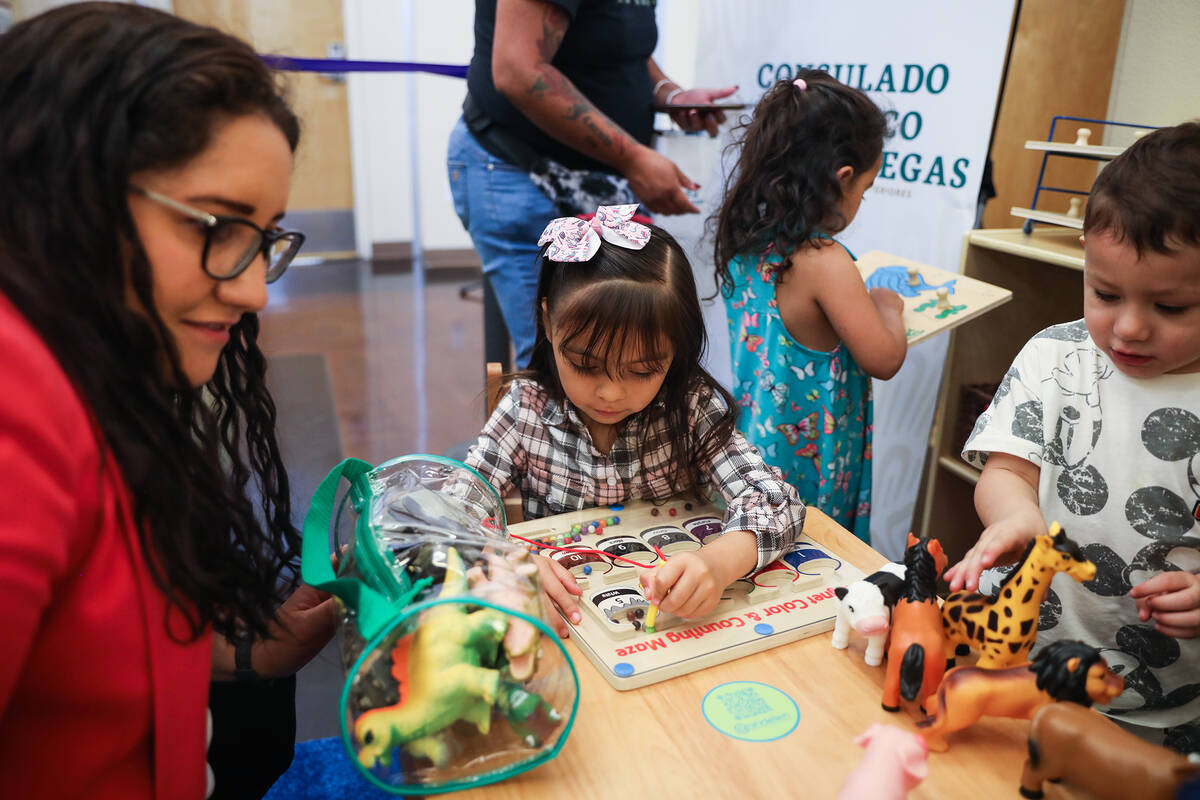 Karlyn Roman, 5, plays with a toy in the newly donated children’s area at the Consulate ...