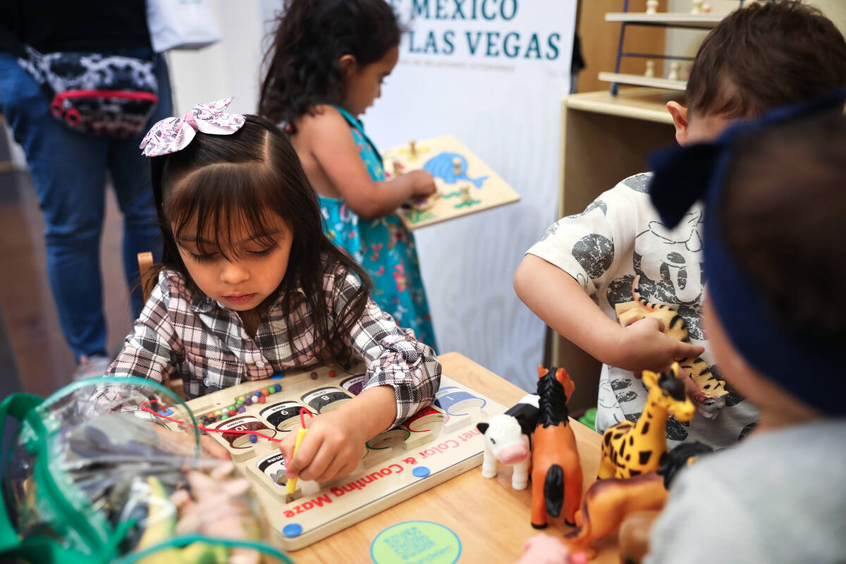 Karlyn Roman, 5, plays with a toy in the newly donated children’s area at the Consulate ...