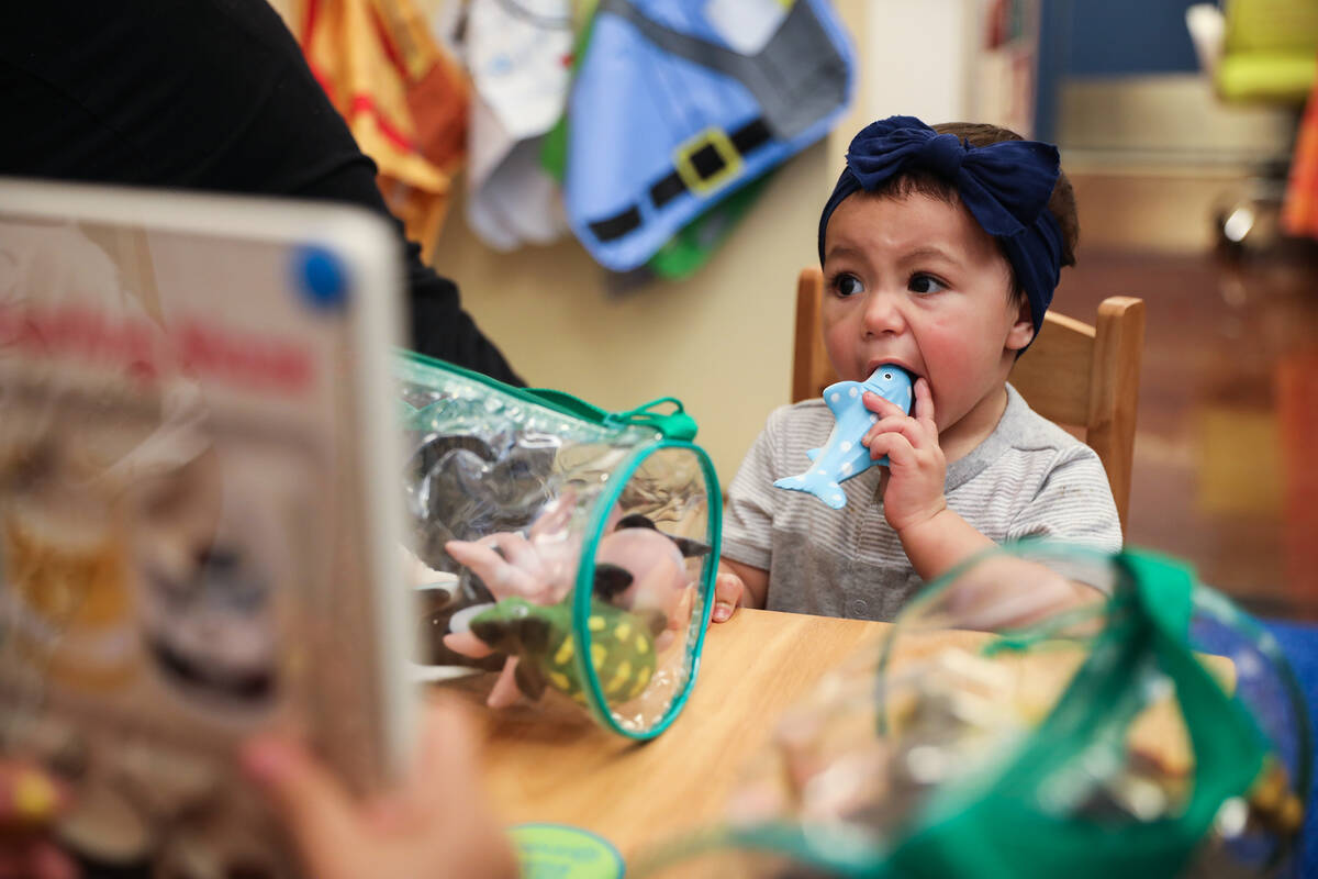 Leah Magallanes, 1, bites on a toy in the newly donated children’s area at an event to c ...