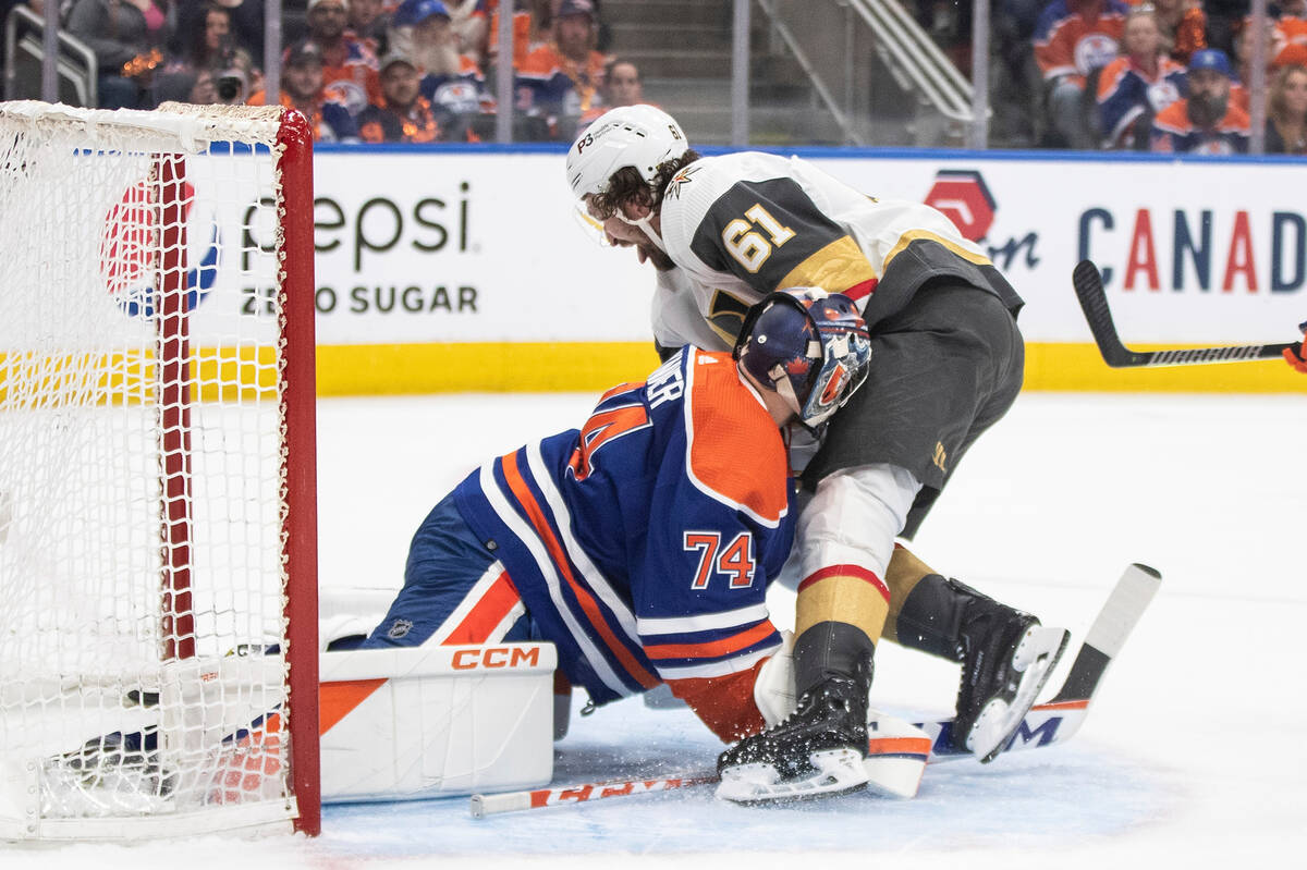 Vegas Golden Knights' Mark Stone (61) crashes into Edmonton Oilers goalie Stuart Skinner (74) d ...