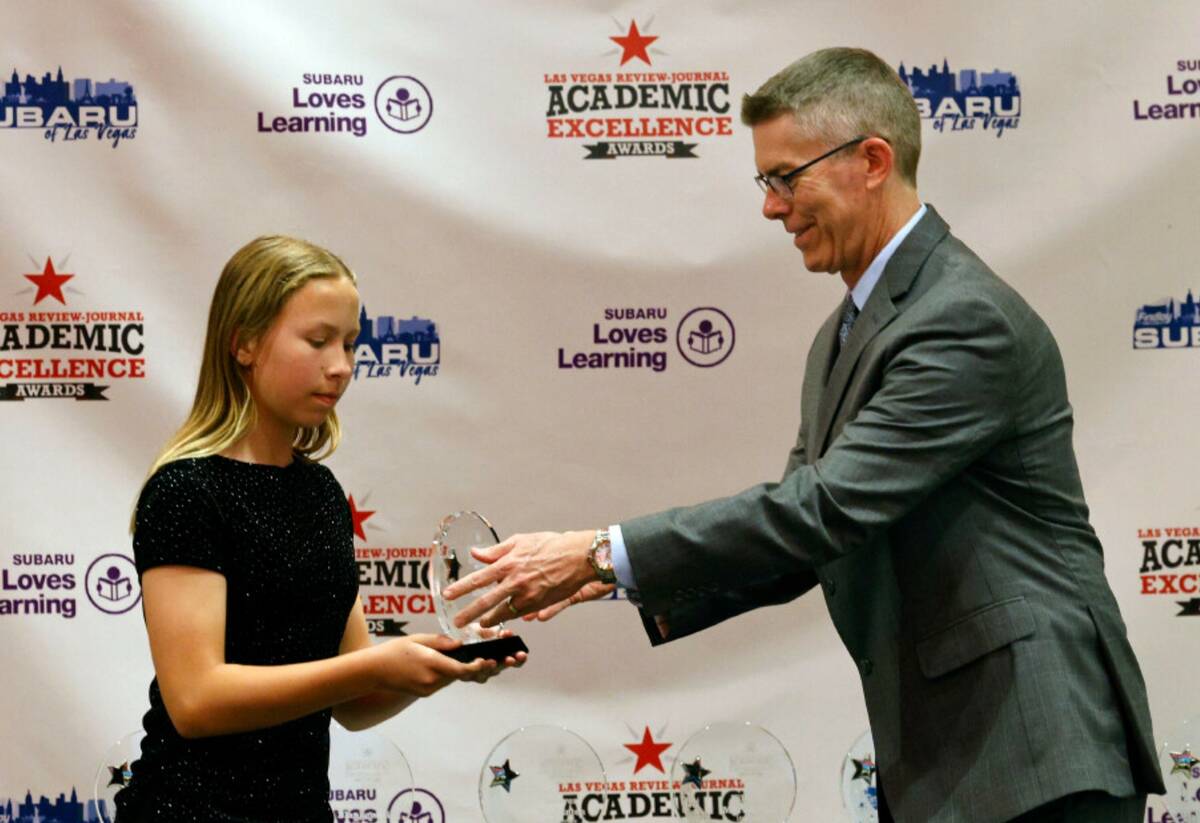 Elizabeth Frus, sixth grader of Garrett Junior High School, receives an award from Glenn Cook, ...