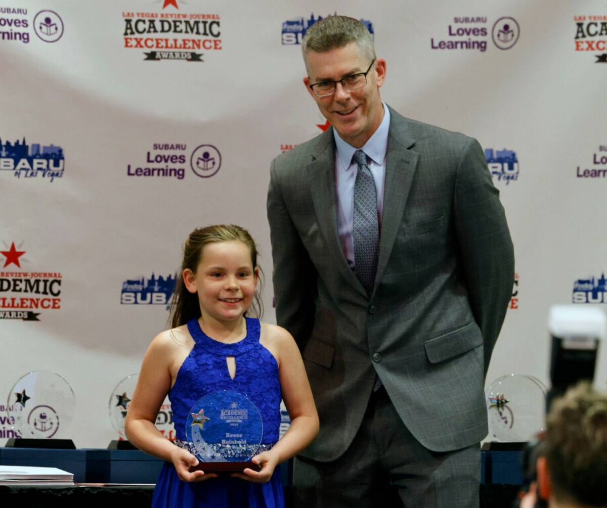 Reese Reinbold, third grader of Kay Carl Elementary School, poses for a photo with Glenn Cook, ...