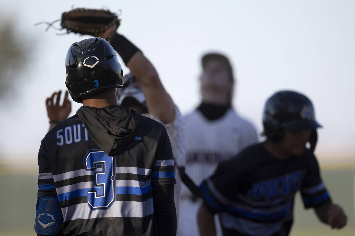 Basic’s Ty Southisene watches as Desert Oasis’ catcher Jake Cook catches his foul ...