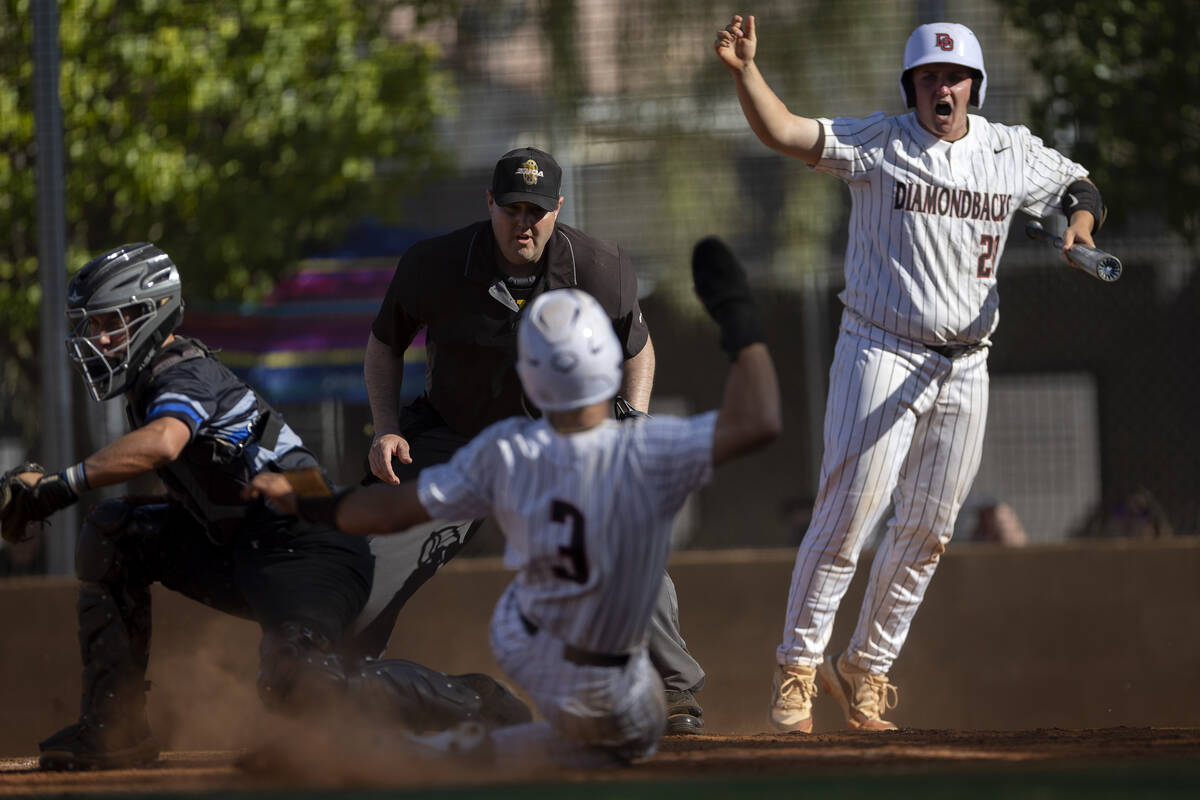 Desert Oasis’ Ethan Kelly (20) cheers as catcher Jake Cook slides into home plate safely ...