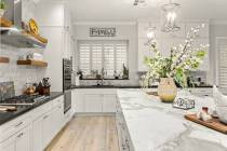 At the heart of the home is a kitchen with a large marble waterfall island. (huntington & ellis)