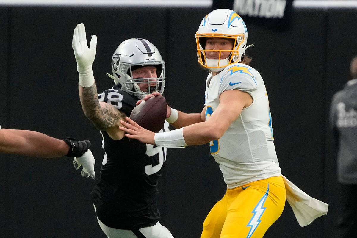 Las Vegas Raiders defensive end Maxx Crosby (98) pressures Los Angeles Chargers quarterback Jus ...