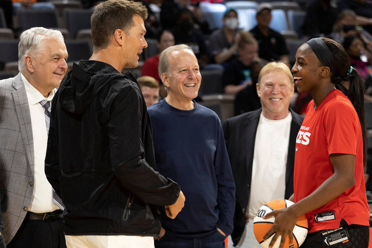 Las Vegas Aces guard Jackie Young (0) laughs with football quarterback Tom Brady, center, durin ...