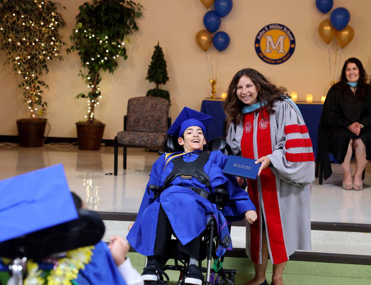 Graduate Nicolas Fernandez gets his diploma from Dr. Monica Cortez during a graduation ceremony ...