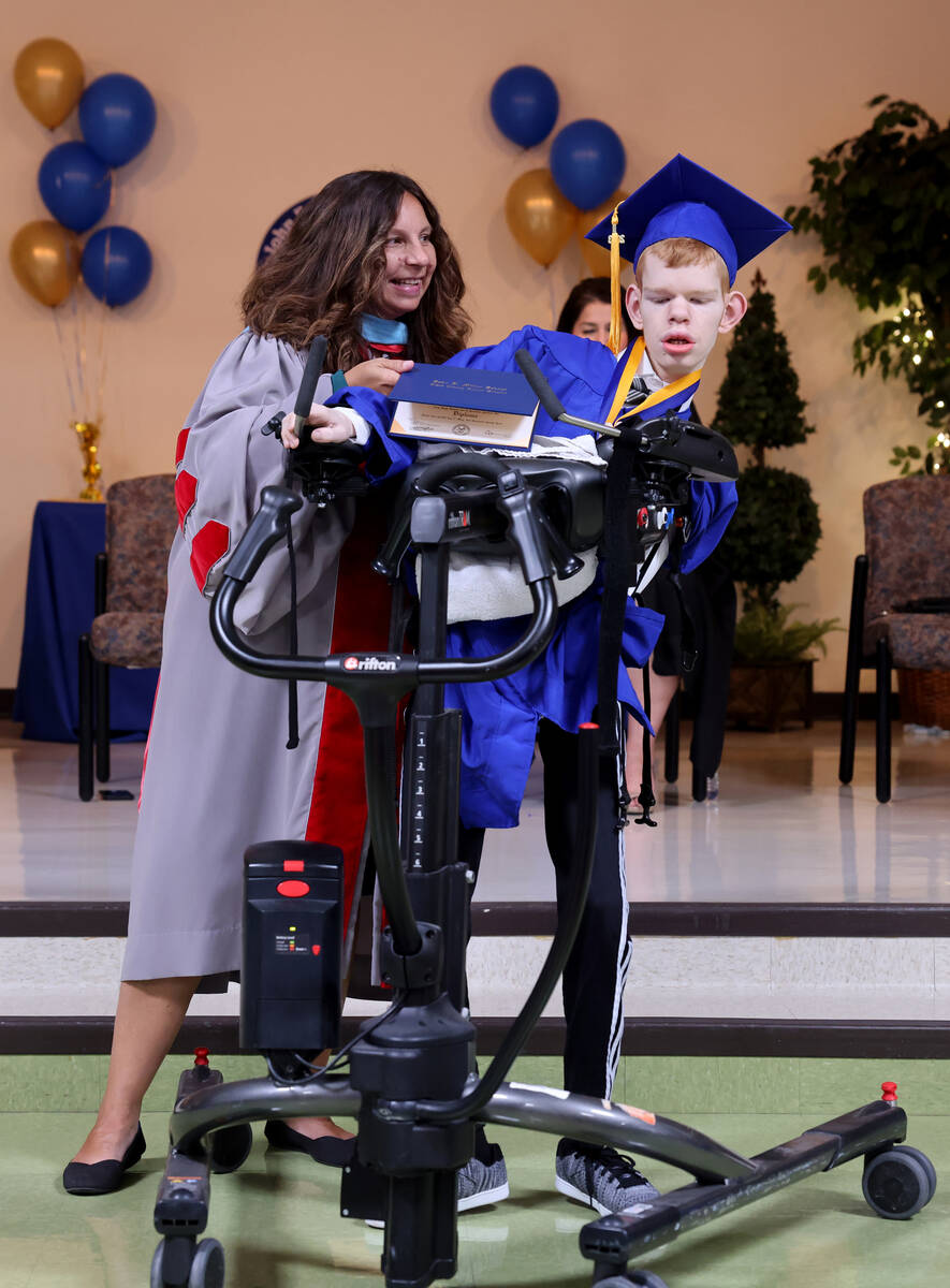 Graduate Max Jensen gets his diploma from Dr. Monica Cortez during a graduation ceremony at Joh ...