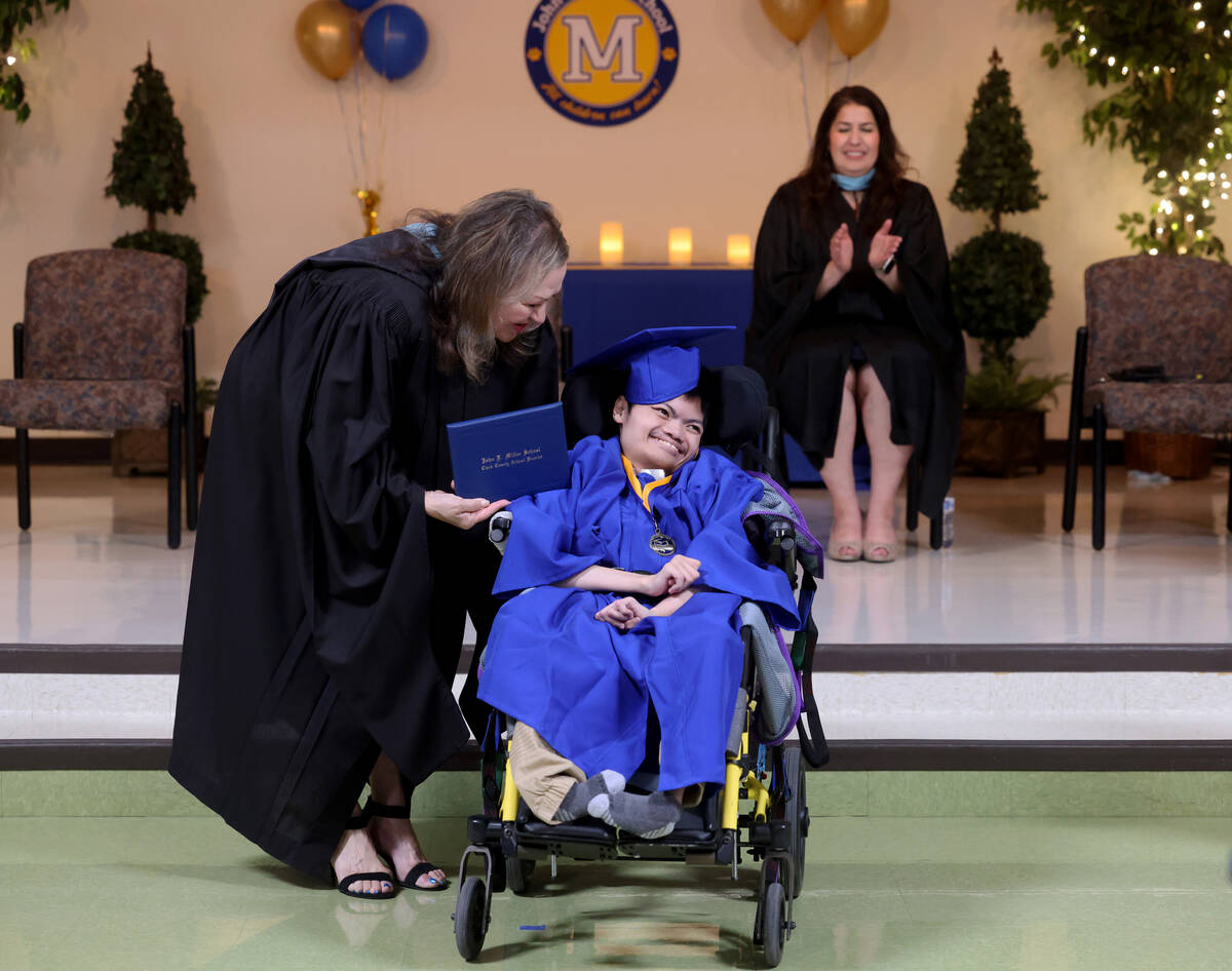 Graduate Hayden Stecyk gets his diploma from Clark County School Board Trustee Linda Cavazos du ...
