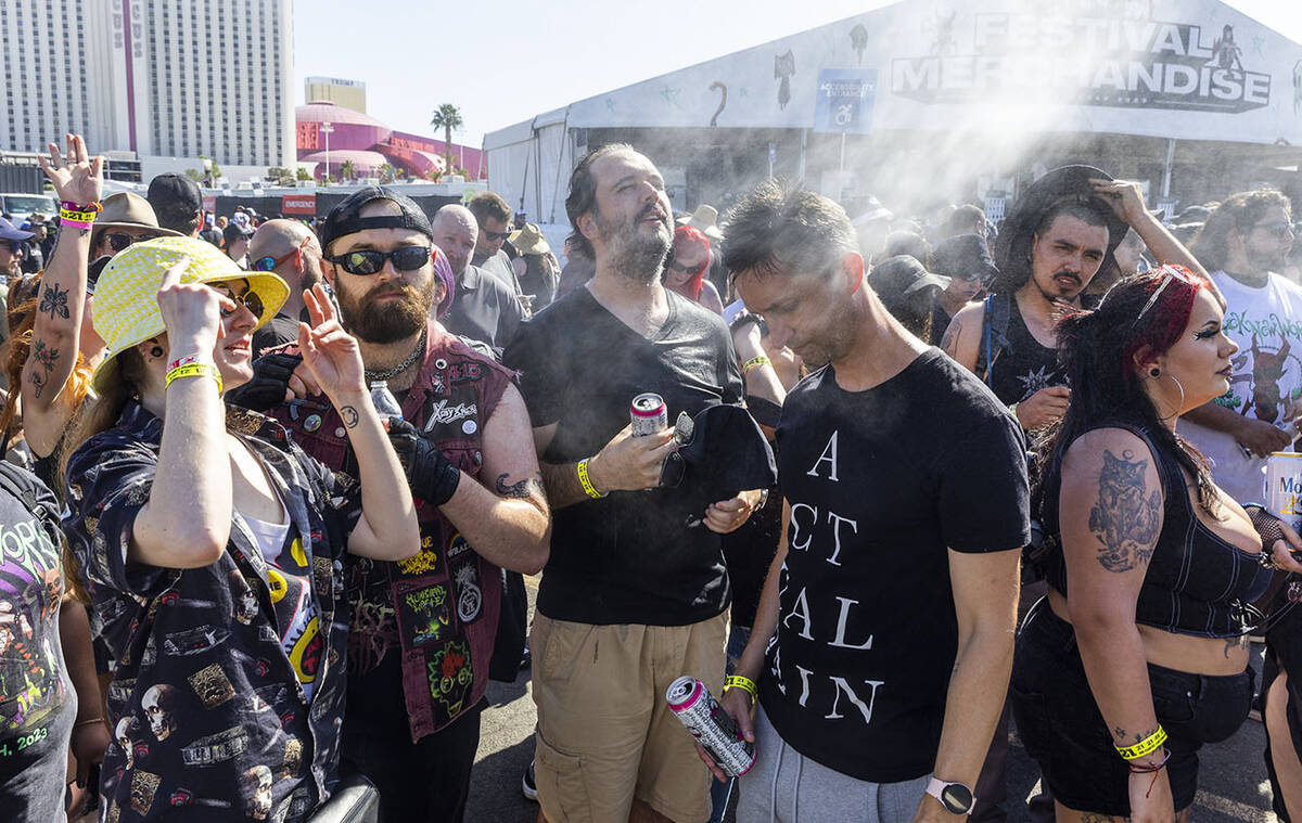 Attendees cool off from the heat during the Sick New World festival at the Las Vegas Festival G ...