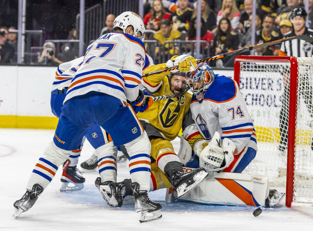 Golden Knights right wing Mark Stone (61) is pushed on a shot by Edmonton Oilers defenseman Bre ...