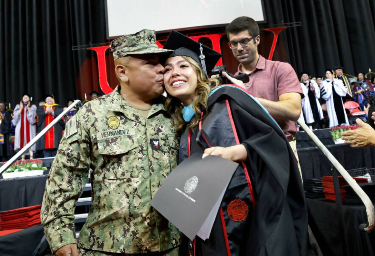 U.S. Navy Petty Officer 2nd Class Douglas Hernandez kisses his daughter Pamela after she receiv ...