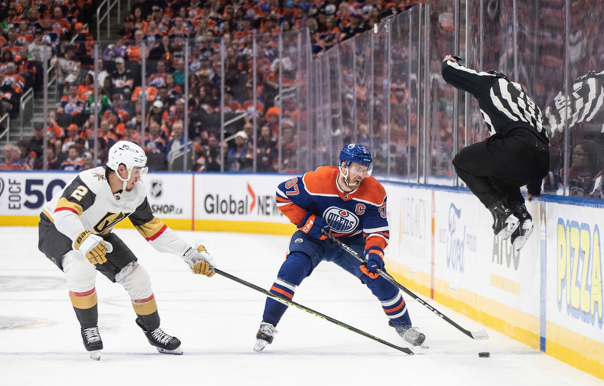 Vegas Golden Knights' Zach Whitecloud (2) and Edmonton Oilers' Connor McDavid (97) battle for t ...