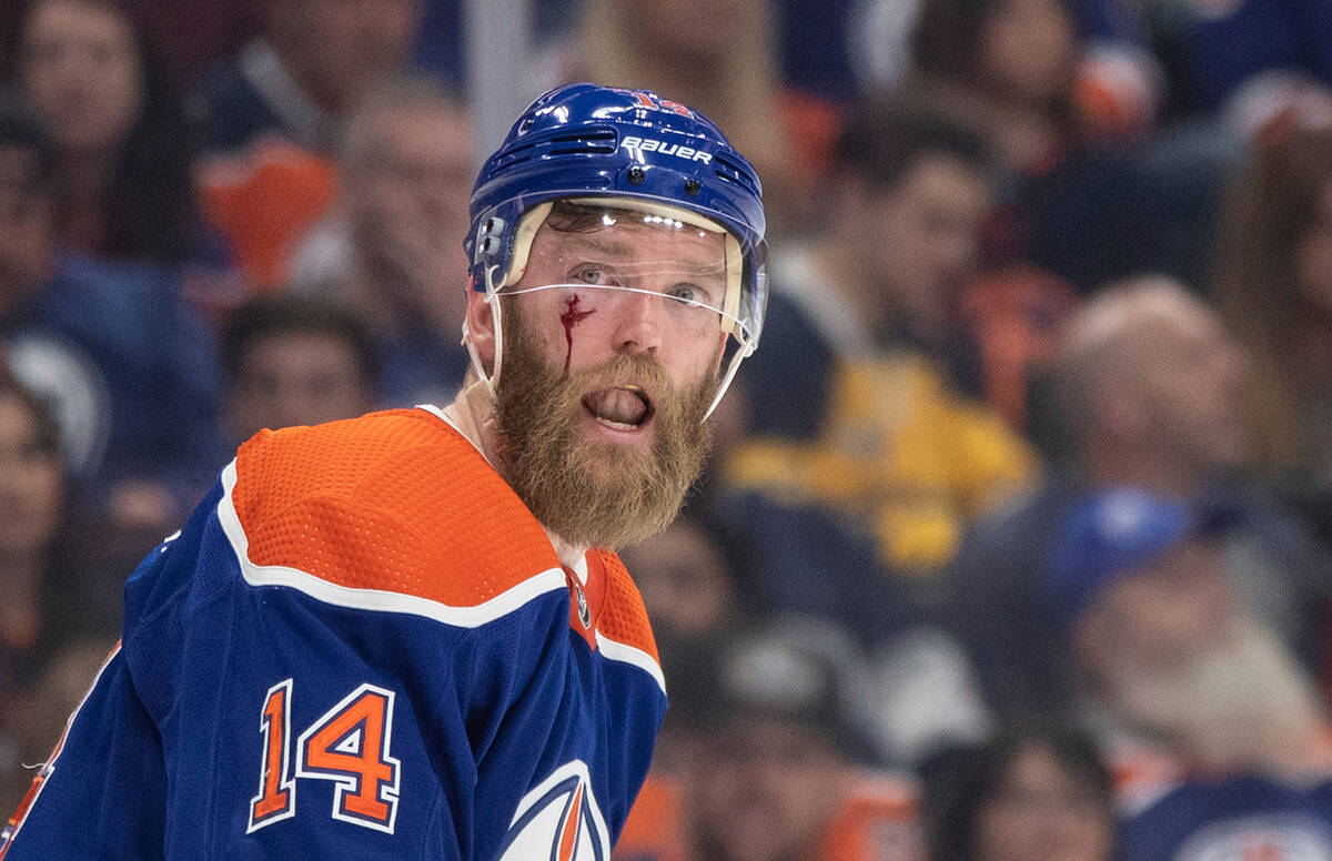 Edmonton Oilers' Mattias Ekholm (14) is cut from a stick to the face during the third period in ...
