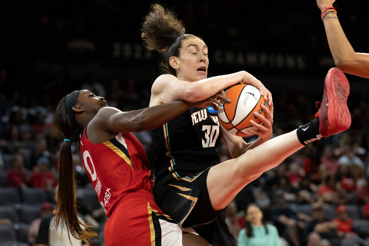 Aces guard Jackie Young (0) struggles for the ball with New York Liberty forward Breanna Stewar ...