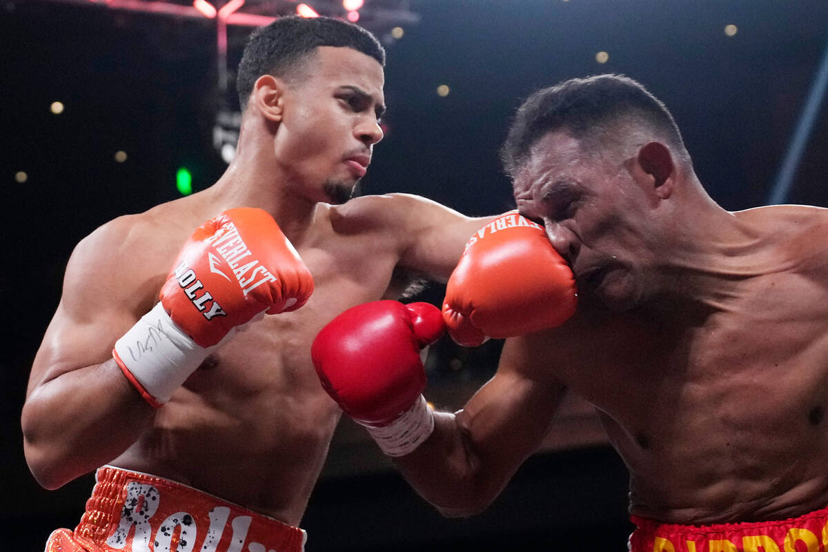 Rolando Romero punches Ismael Barroso in a super lightweight title boxing match Saturday, May 1 ...
