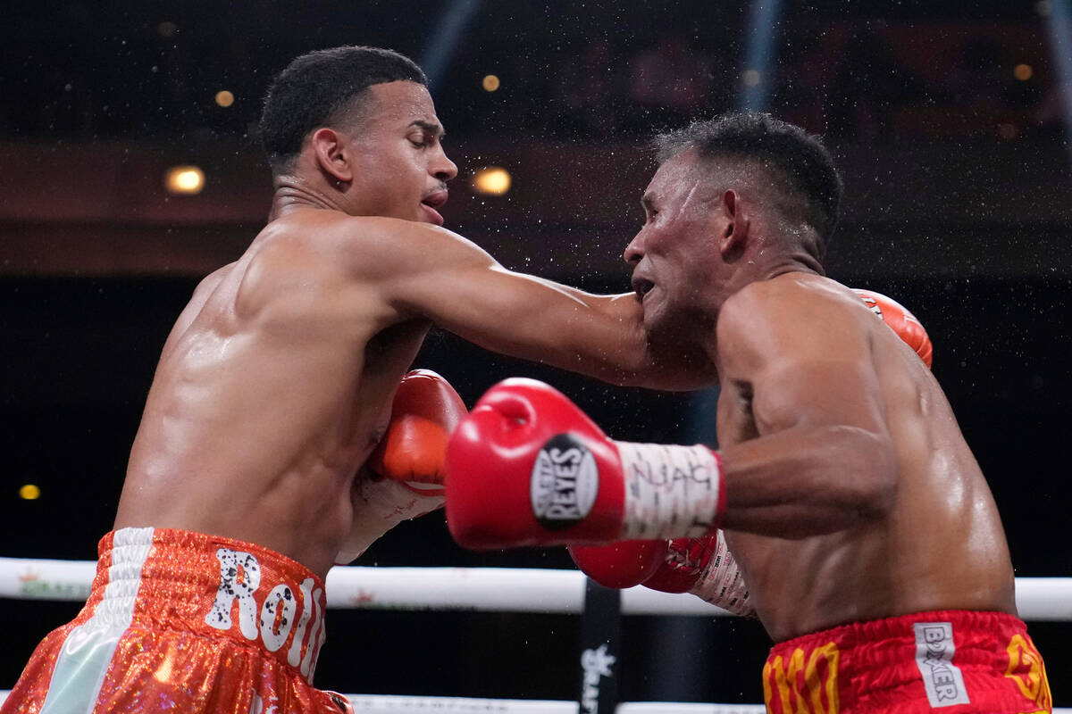 Rolando Romero, left, hits Ismael Barroso in a super lightweight title boxing match Saturday, M ...