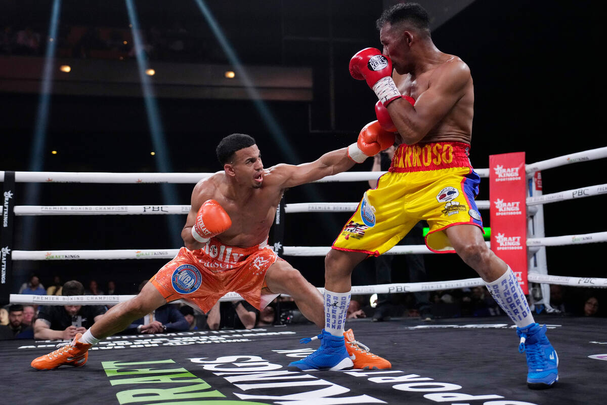 Rolando Romero, left, fights Ismael Barroso in a super lightweight title boxing match Saturday, ...