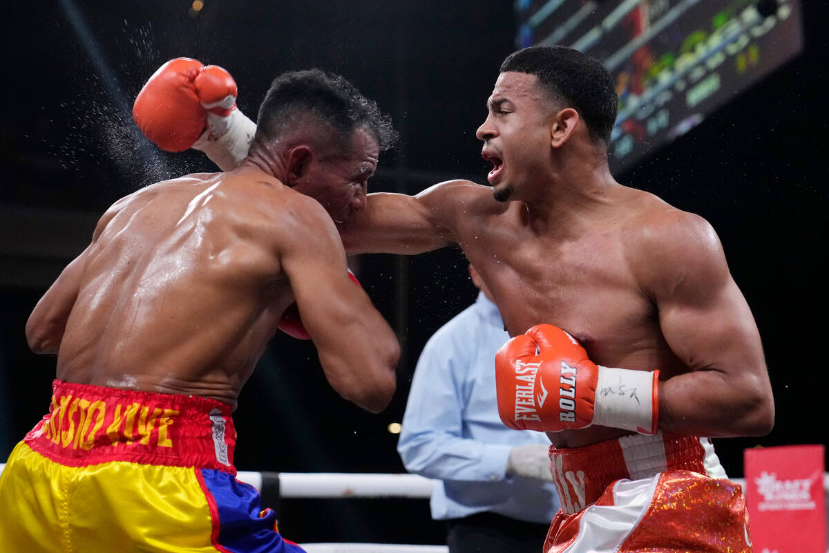 Rolando Romero punches Ismael Barroso in a super lightweight title boxing match Saturday, May 1 ...