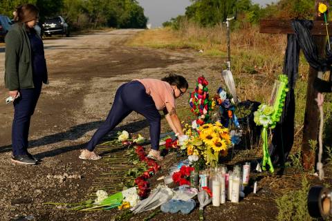 Mourners pay their respects at a makeshift memorial at the site where officials found dozens of ...