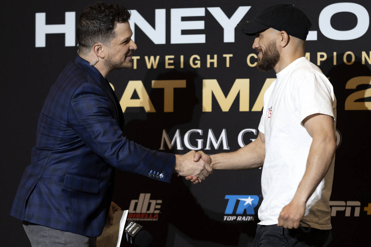 Vasily Lomachenko shakes hands with emcee Mark Shunock after arriving to MGM Grand ahead of his ...