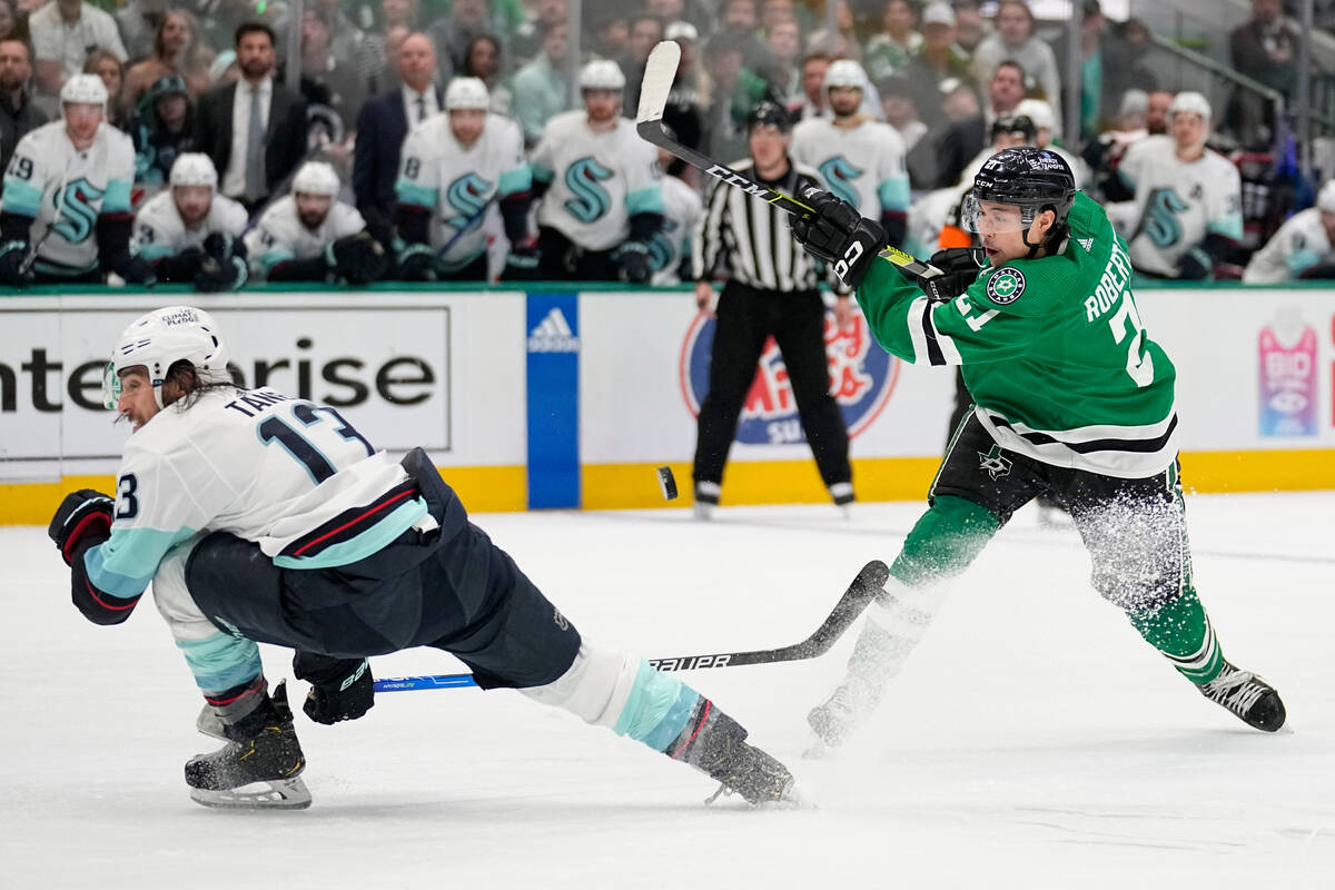 Seattle Kraken left wing Brandon Tanev (13) takes a hit from the puck on a shot by Dallas Stars ...
