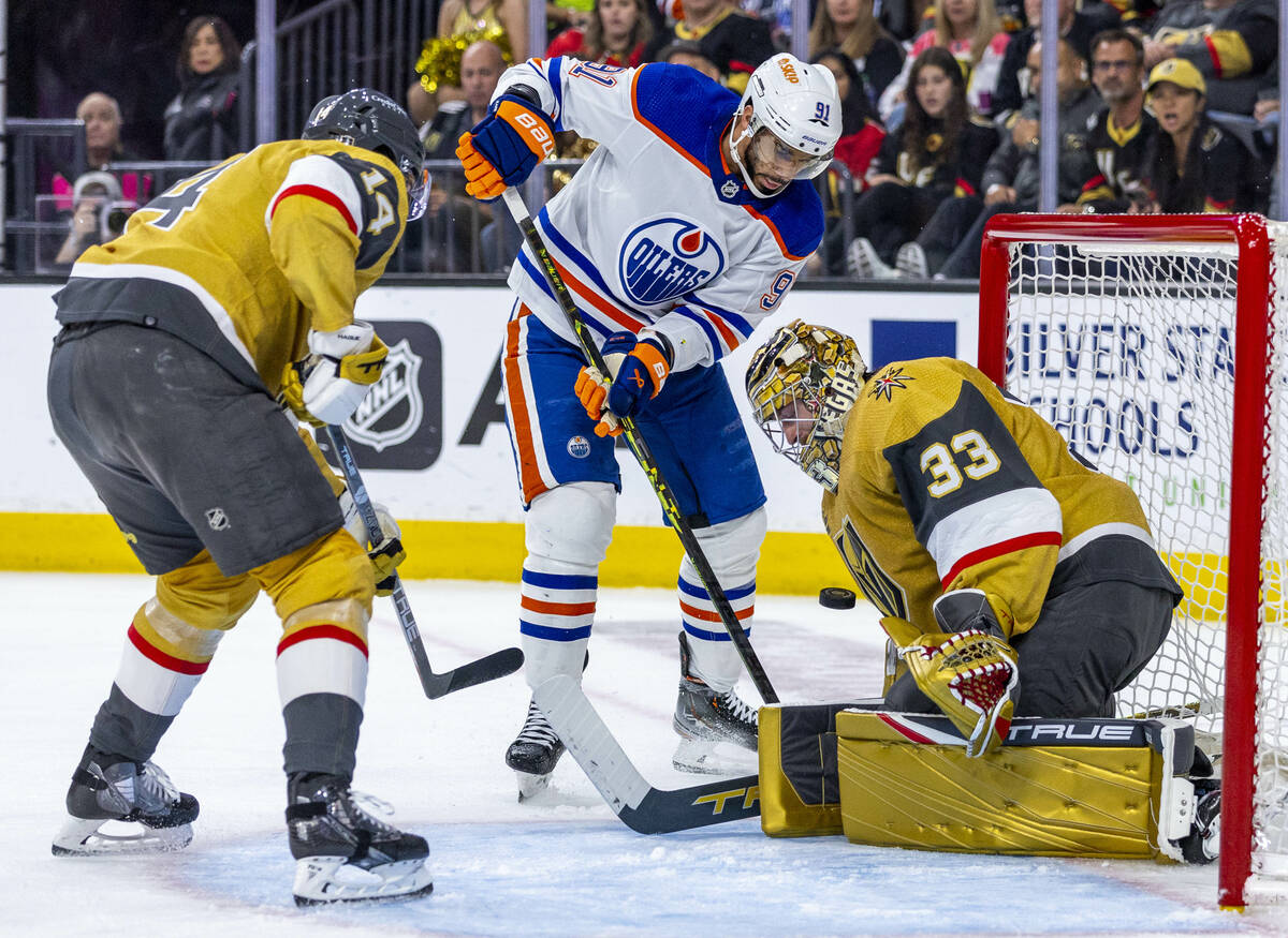 Golden Knights goaltender Adin Hill (33) deflects a puck off his chest from Edmonton Oilers lef ...