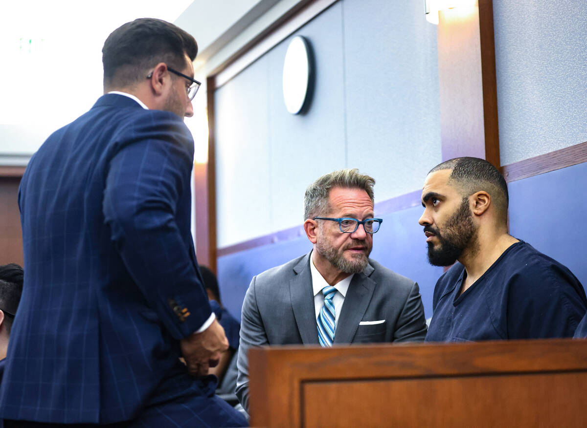 Justin Carter, right, speaks with his attorneys Michael Horvath, left, and Robert Draskovich, c ...