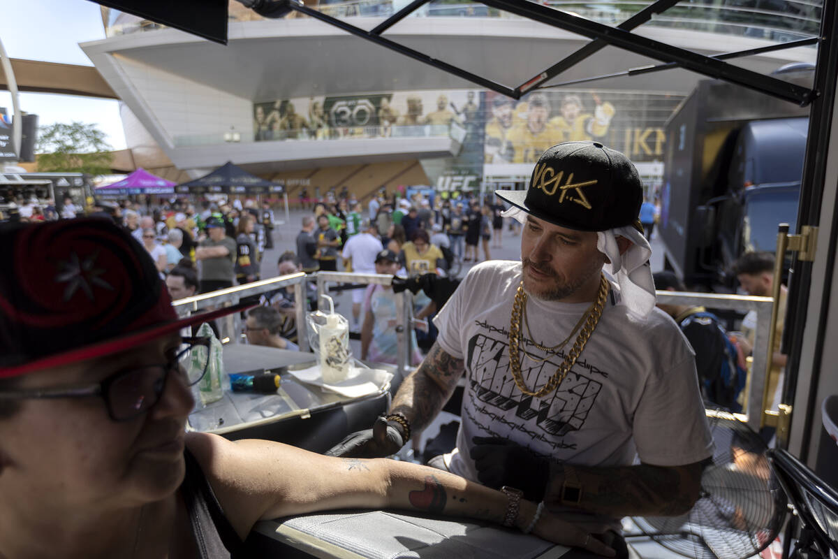 Tattoo artist Jason Capps checks his work on a Golden Knights piece for Las Vegan Lalenia Andre ...