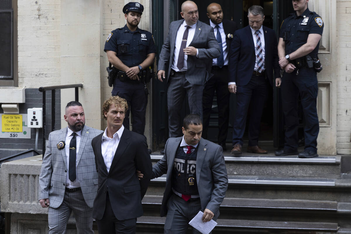 Daniel Penny, center, is walked by New York Police Department detectives detectives out of the ...