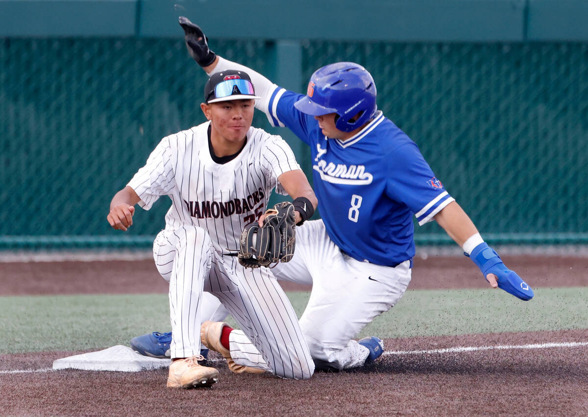 Bisho Gorman High's Gunnar Myro slides around Desert Oasis High's third baseman Joell Castro du ...