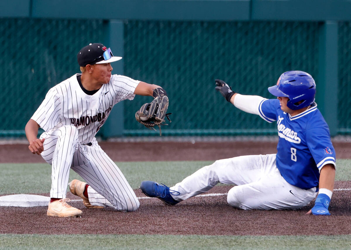 Bisho Gorman High's Gunnar Myro slides around Desert Oasis High's third baseman Joell Castro du ...