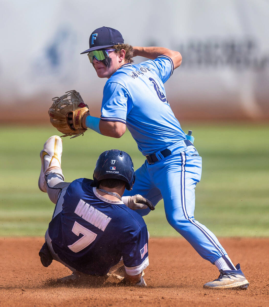 Foothill 2B Thayne Watson makes the tag as Shadow Ridge runner Evan Harnum slides in late durin ...