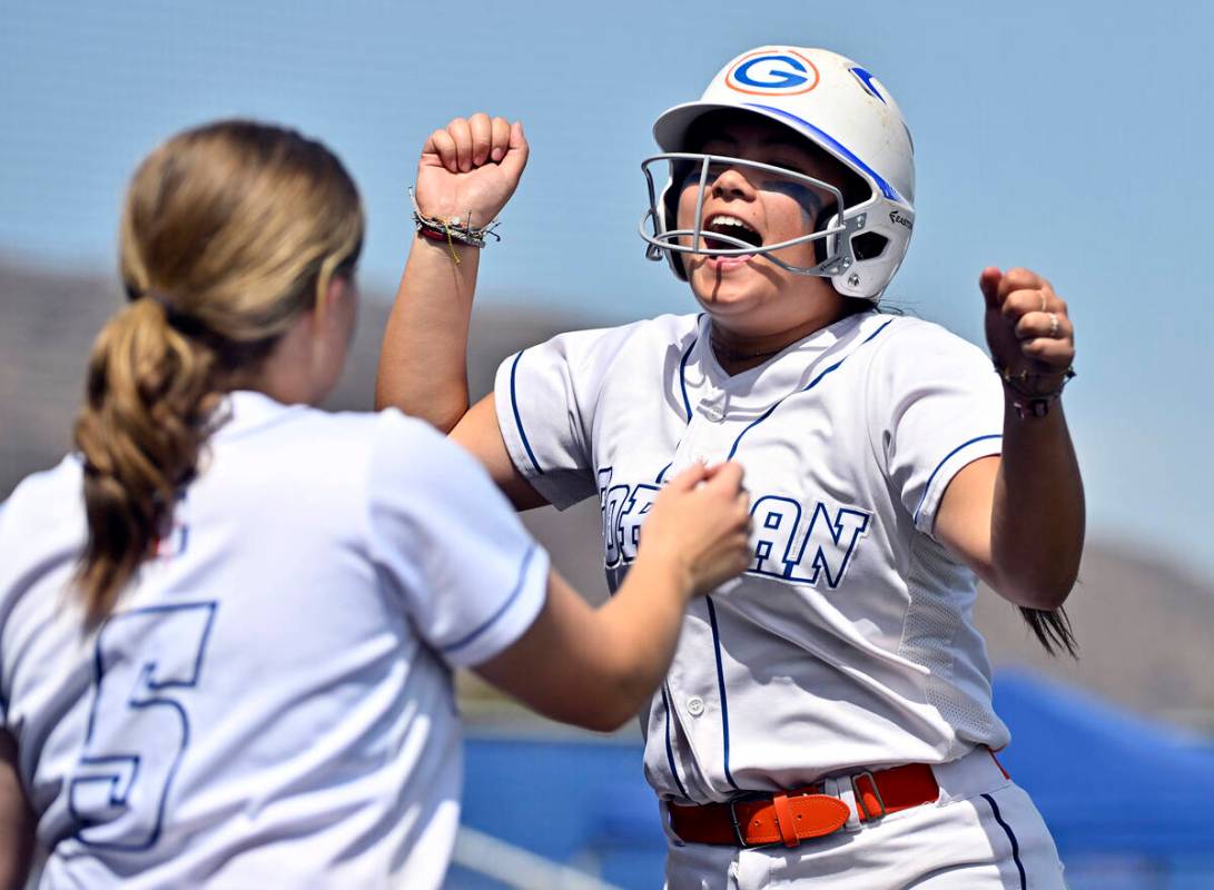 Bishop Gorman’s Kyla Acres, rights, celebrates scoring a run with teammate Samantha Lefe ...