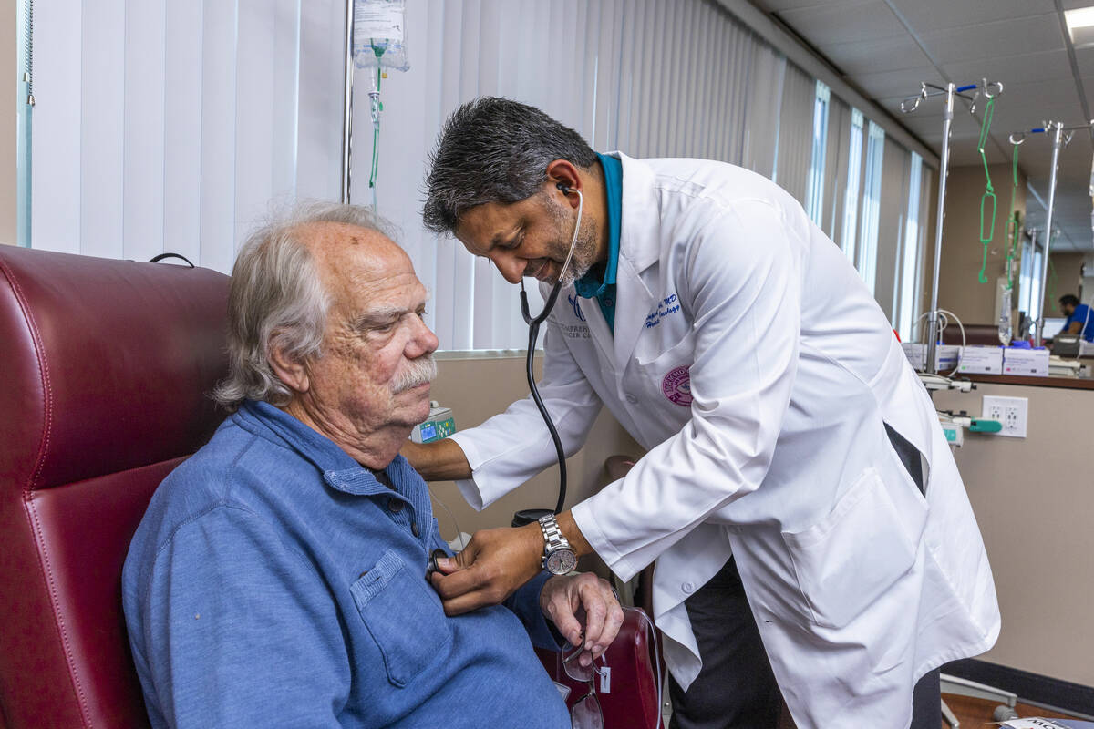 Dr. Rupesh Parikh, right, checks the heart of patient Scott Long of Las Vegas in the chemo trea ...