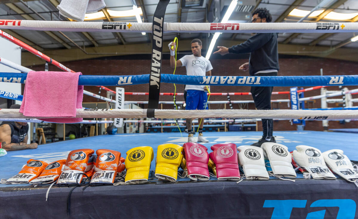 WBC lightweight boxer Devin Haney, left, talks in the ring with his father Bill during a workou ...