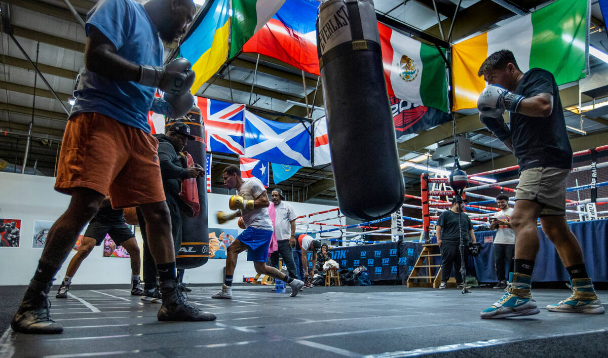WBC lightweight boxer Devin Haney, center rear, throws a punch on a heavy bag as other boxers p ...